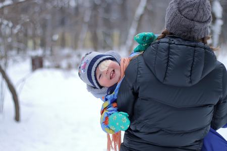 Little boy looking from behind a back momの写真素材