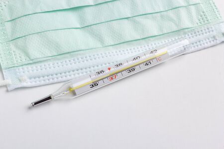 medical thermometer and protective face mask isolated on white backgroundの写真素材