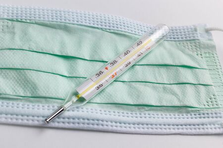 medical thermometer and protective face mask isolated on white backgroundの写真素材