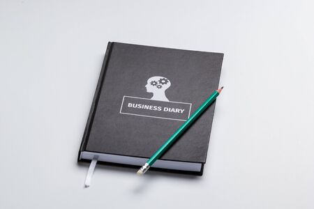 business diary and pencil on white background isolatedの写真素材