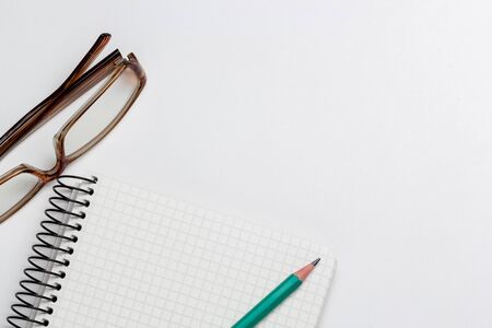 notebook, pen and glasses on white background isolatedの写真素材