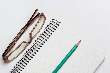notebook, pen and glasses on white background isolatedの写真素材