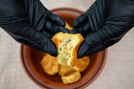 fried potato cutlets in a bowl and in the hands of a personの写真素材