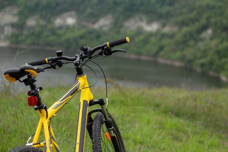 Yellow bicycle on green grass by the riverの写真素材