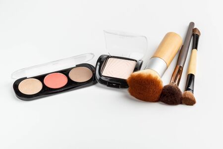 Makeup brushes of different sizes and makeup powder on a white backgroundの写真素材