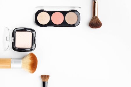Makeup brushes of different sizes and makeup powder on a white background. Top view.の写真素材
