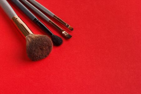 Makeup brushes of different sizes on a red backgroundの写真素材