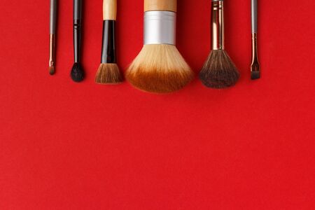 Makeup brushes of different sizes on a red backgroundの写真素材