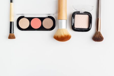 Makeup brushes of different sizes and makeup powder on a white background. Top view.の写真素材