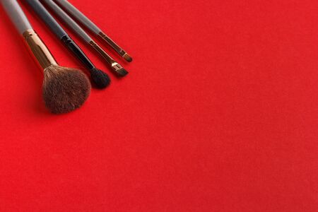 Makeup brushes of different sizes on a red backgroundの写真素材