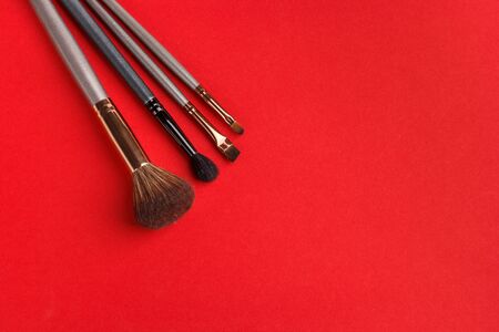 Makeup brushes of different sizes on a red backgroundの写真素材