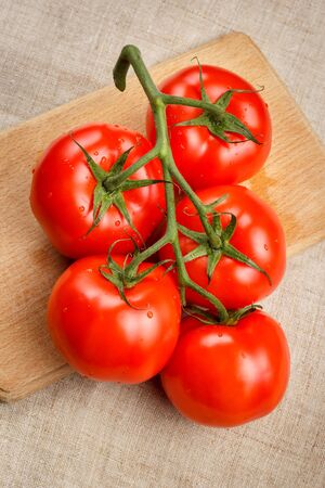 Juicy red tomatoes on a cutting board. Top view.の写真素材