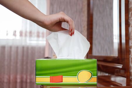 female hand pulls a napkin out of the boxの写真素材