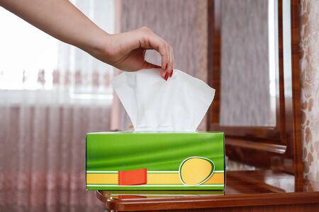 female hand pulls a napkin out of the boxの写真素材