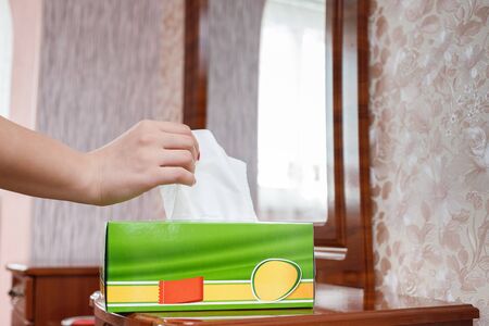 female hand pulls a napkin out of the boxの写真素材