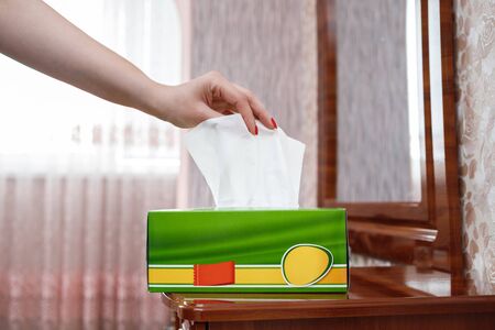 female hand pulls a napkin out of the boxの写真素材
