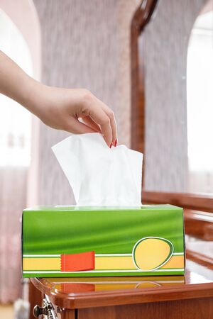 female hand pulls a napkin out of the boxの写真素材