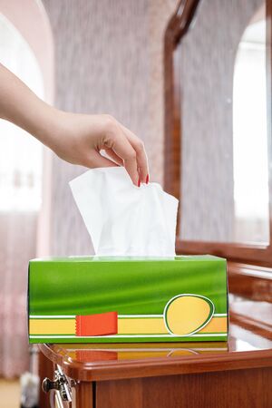 female hand pulls a napkin out of the boxの写真素材