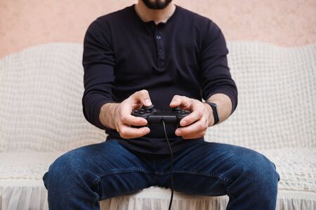 A man plays video games with a joystick in his hands