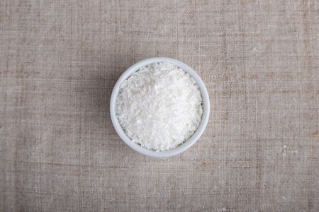 Coconut flakes in a bowl on the table