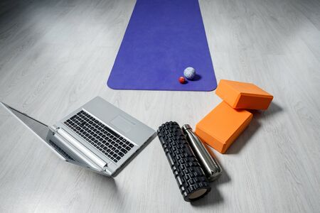 Laptop, yoga roller, yoga bricks, yoga mat, and small fitness balls. Yoga and fitness equipment.の写真素材