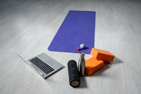 Laptop, yoga roller, yoga bricks, yoga mat, and small fitness balls. Yoga and fitness equipment.の写真素材