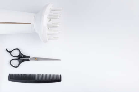 Hairdryer for drying hair scissors and comb on a white backgroundの写真素材