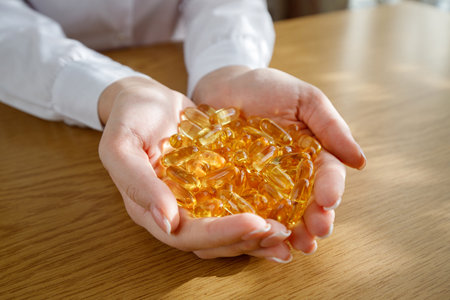 A young girl holds in her palms a lot of fish oil capsules.の写真素材