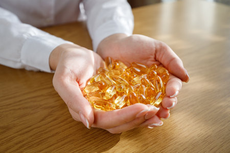A young girl holds in her palms a lot of fish oil capsules.の写真素材