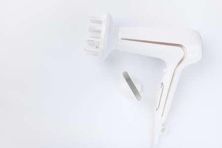 Hairdryer for drying hair with a diffuse and flat nozzle for styling on a white background. Top...