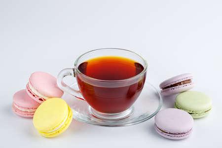 Cup of tea and colorful macaroons on a white background.の写真素材
