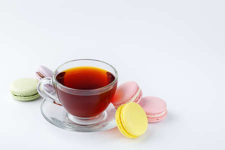 Cup of tea and colorful macaroons on a white background.の写真素材