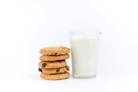 A glass of milk and cookies with raisins on a white backgroundの写真素材