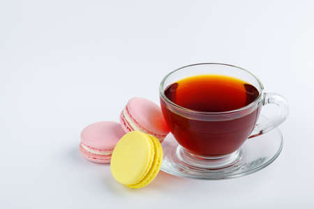 Cup of tea and colorful macaroons on a white background.の写真素材