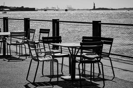 Black and white landscape. Chairs and desks on the pier.の写真素材
