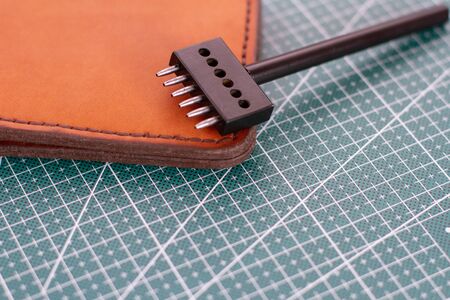 punch for leather and leather wallet on freen cutting matの写真素材