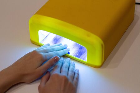 manicure process in lamp, women hand. isolatedの写真素材