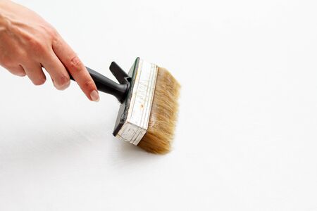 hand with a brush wallpaper glue on white backgroundの写真素材