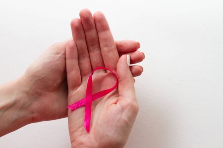 Women hands holding pink ribbons. October Pink day background
