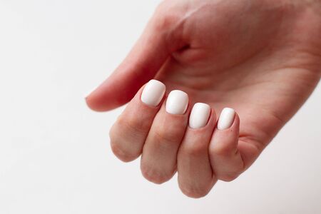 female hands with a beautiful gel polish manicure on white backgroundの写真素材