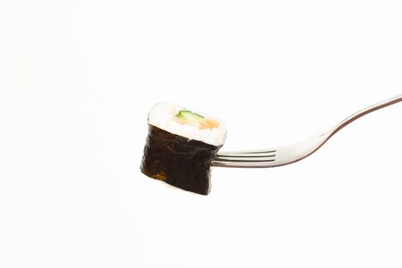 fresh sushi roll in fork on white backgroundの写真素材