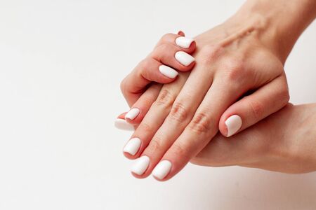 gentle female hands with a beautiful gel polish manicure isolatedの写真素材