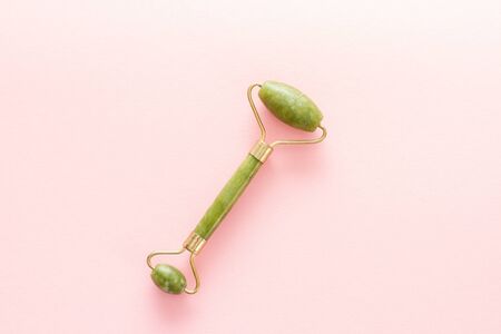 green jade stone massager on a pink backgroundの写真素材