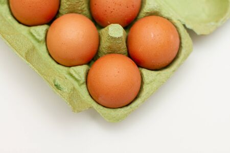 brown chicken raw eggs in a green paper egg containerの写真素材
