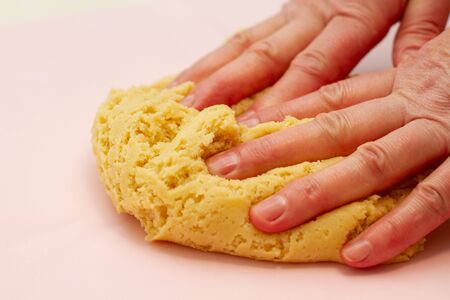female hands prepare dough on the kitchen tableの写真素材