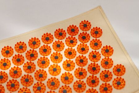 a orange acupuncture mat for treatment on white backgroundの写真素材