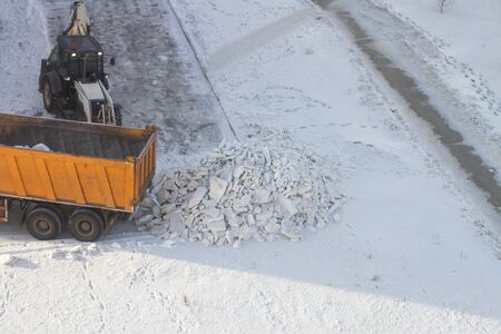 The process of snow removal by bulldozer on the city roadの写真素材