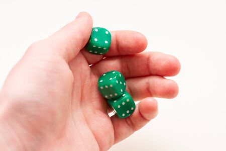 hand holding a green dices on white isolated background. selective focus