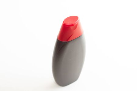black empty shampoo bottle with red cap on a white backgroundの写真素材