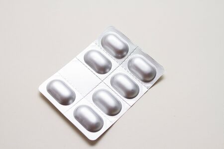 a silver blister with pills on white background